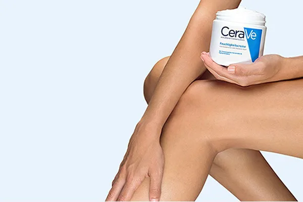 Frau cremt sich die Beine mit der CeraVe Feuchtigkeitscreme ein